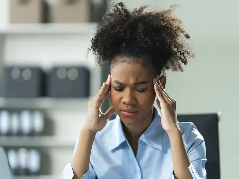 Physical therapist checking neck and shoulder muscle tension during a headache evaluation