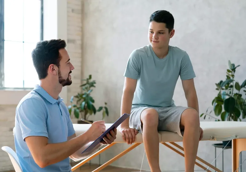 Licensed physical therapist reviewing an ongoing exercise plan with a returning patient in the Lakewood clinic